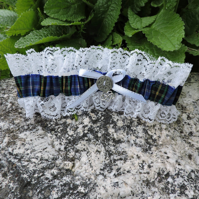 Garter with lace and Nova Scotia Tartan on a stone surface with green leaves in the background